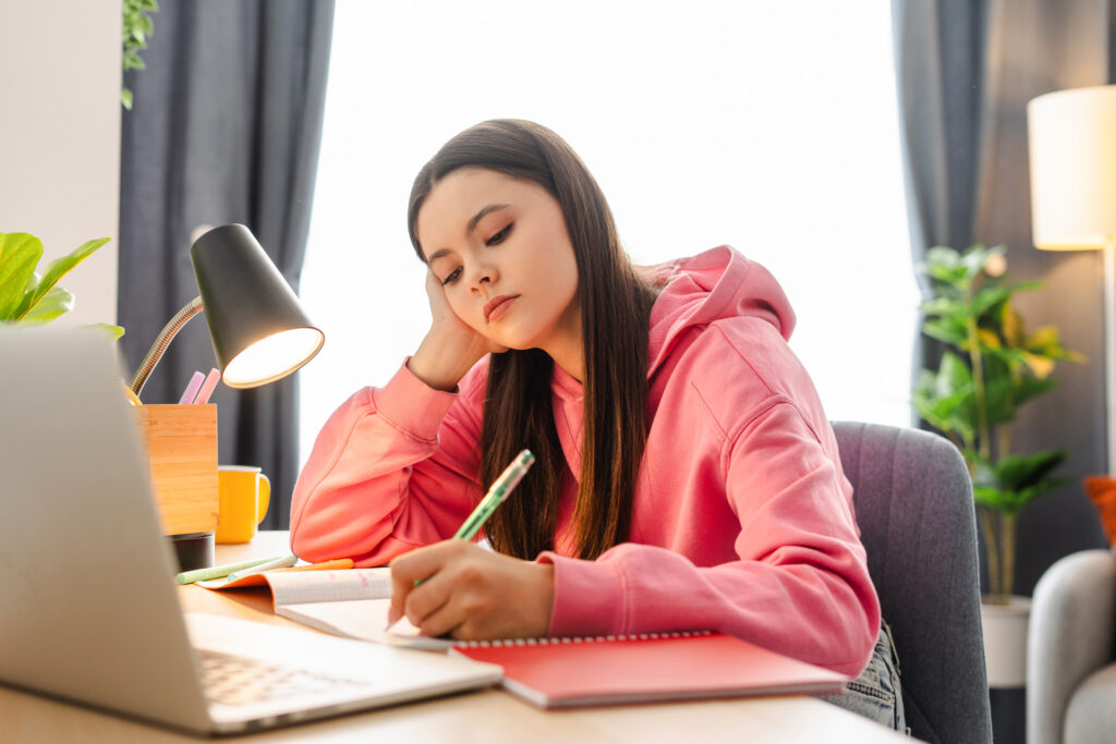 teenage girl writing on her planner