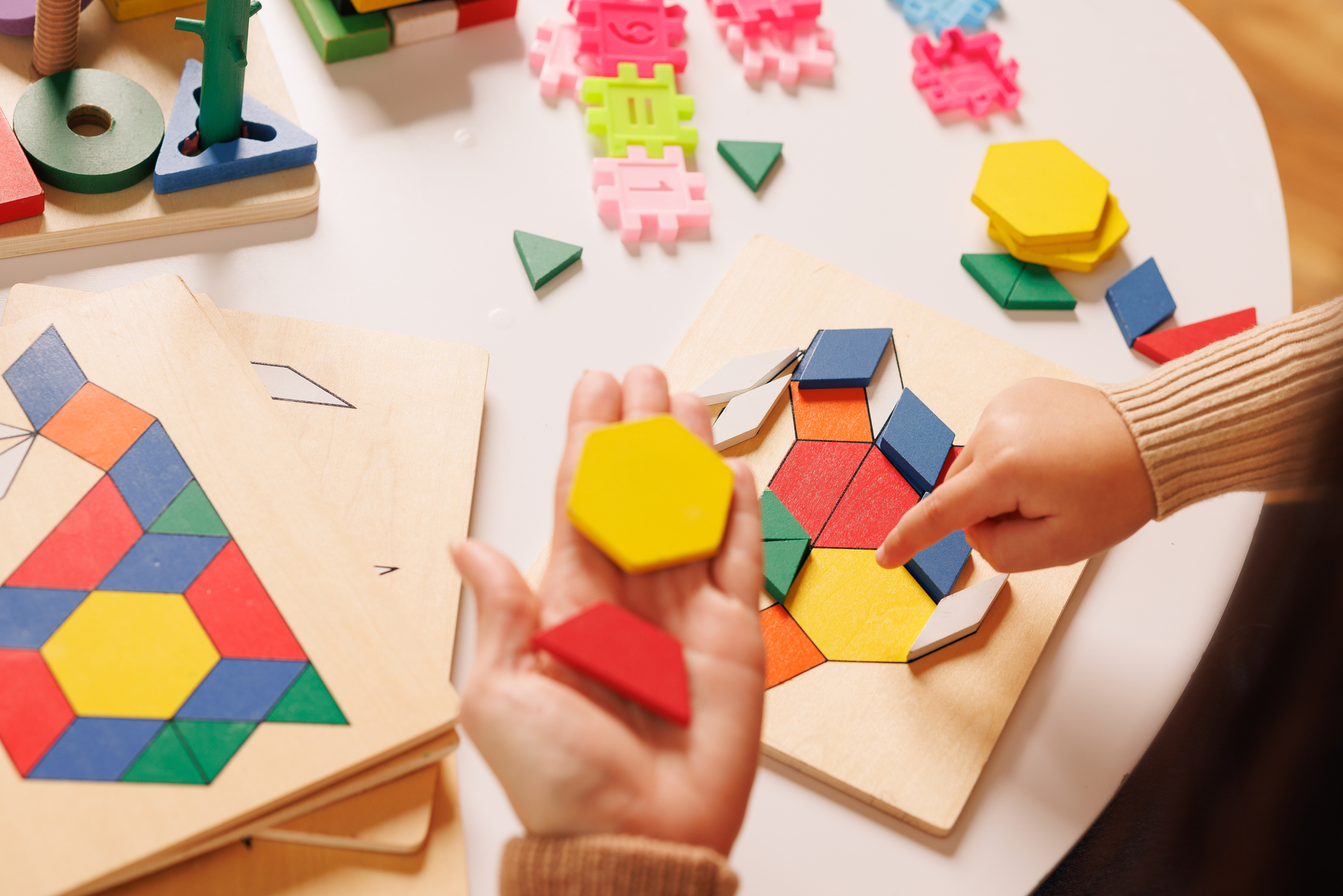 Child and parent playing with a colorful wooden educational toy