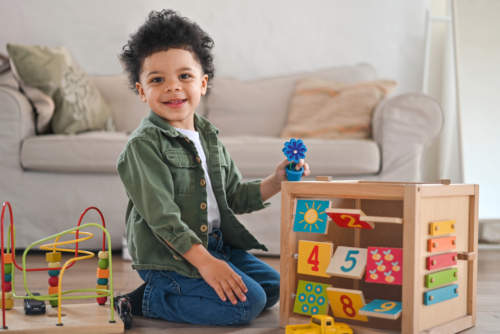 boy playing toys sitting on warm floor in modern living room