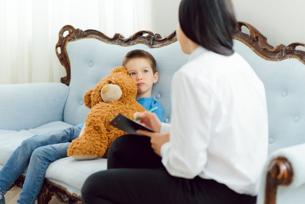 Female psychologist calming cute little boy