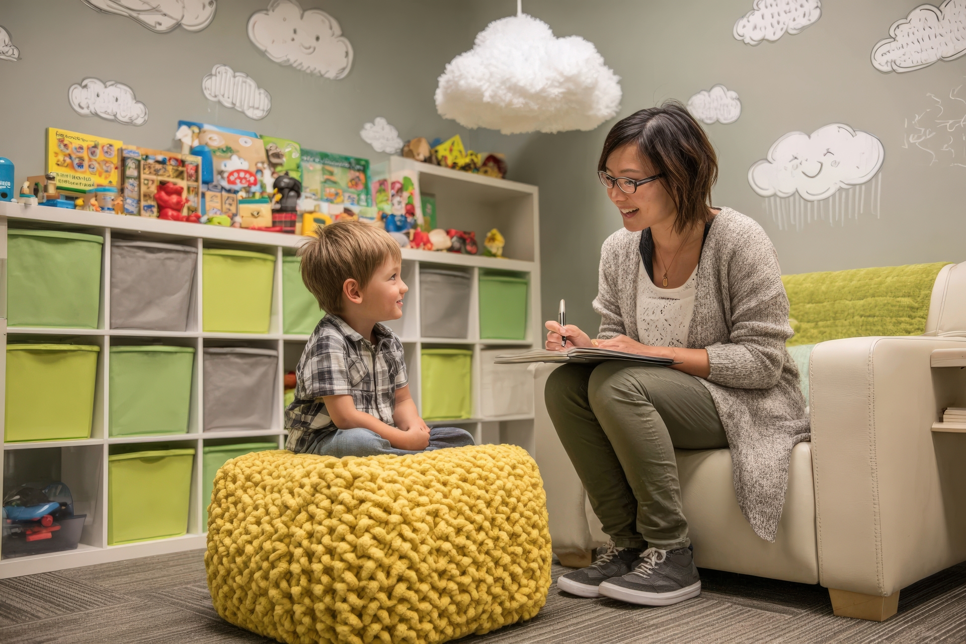 Female therapist engaging with young boy in a colorful playroom