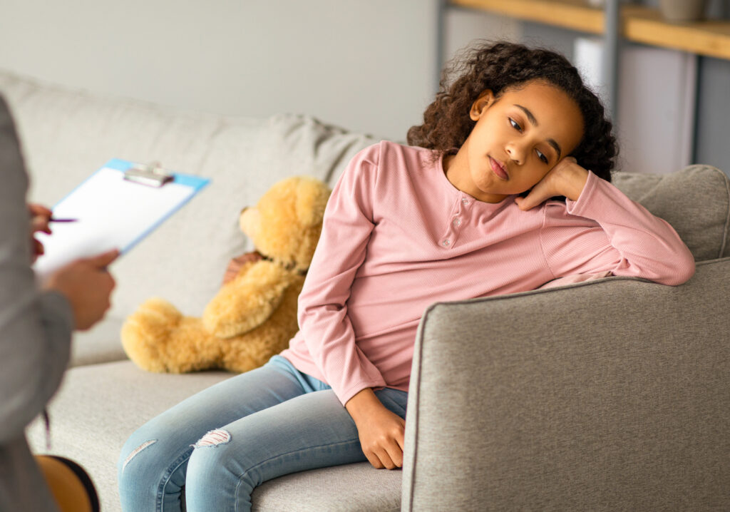 Teenage depression. Psychologist working with upset girl in office, teen thinking about her problems