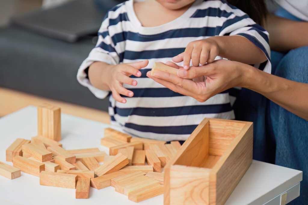 Close-up of mother helping son with building blocks