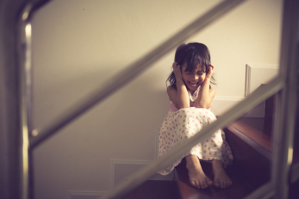 child sitting on stairs crying
